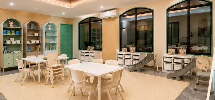 The playroom and tutorial room at Teacher A's House of Learning Laoag City, with child-height tables, reading shelves and an indoor slide.